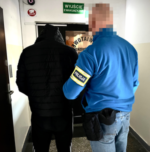 Policjant prowadzi zatrzymanego