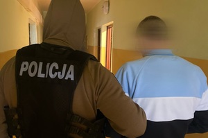 policjanci prowadzą zatrzymanego