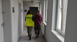 policjantka prowadzi zatrzymanego