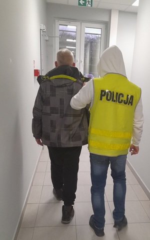 policjant prowadzi zatrzymanego