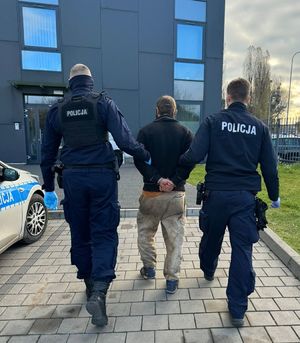 policjanci prowadzą zatrzymanego