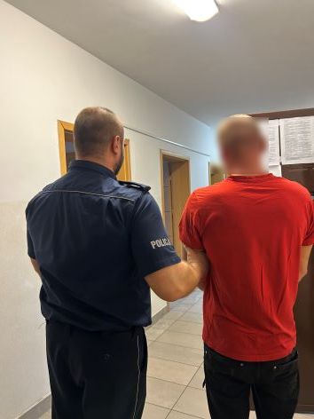 Policjant prowadzi zatrzymanego