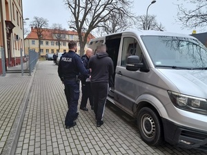 policjant z zatrzymanym poszukiwanym za oszustwa