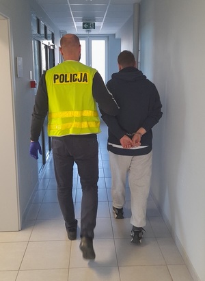policjant prowadzi zatrzymanego