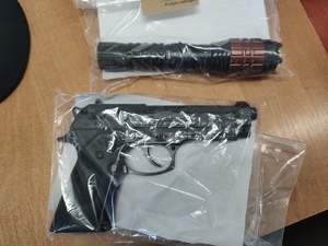 policjant z zatrzymanym i zabezpieczona atrapa broni