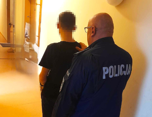 policjant prowadzi zatrzymanego