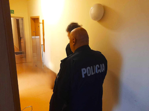 policjant prowadzi zatrzymanego