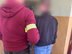 policjant prowadzi zatrzymanego