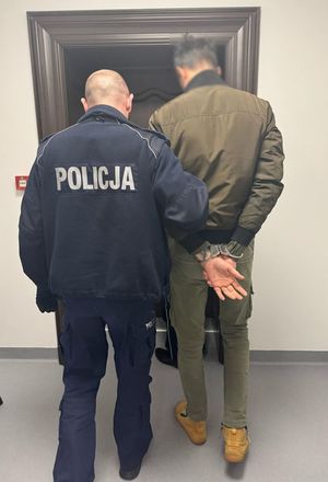 policjant prowadzi zatrzymanego