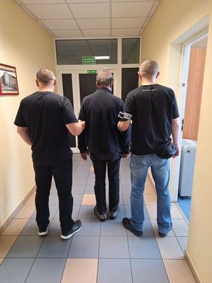 policjanci prowadzą zatrzymanego