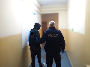 policjant prowadzi zatrzymanego