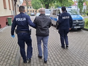 policjanci prowadzą zatrzymanego