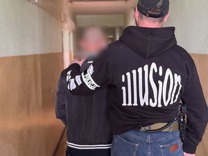 policjant prowadzi zatrzymanego