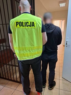 policjant prowadzi zatrzymanego