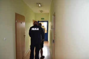 policjant prowadzi zatrzymanego