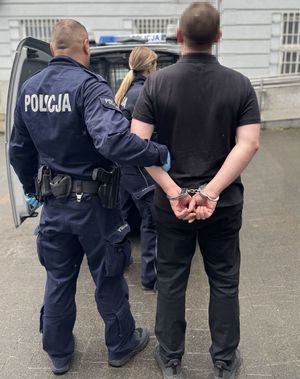 policjant prowadzi zatrzymanego