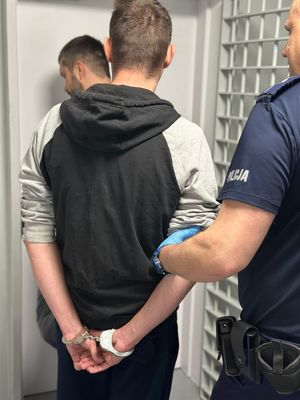 policjant prowadzi zatrzymanego