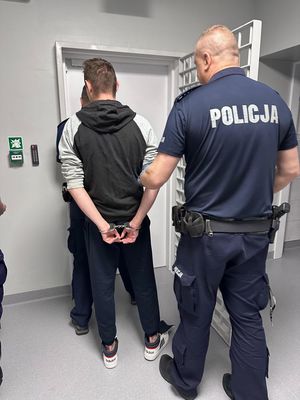 policjant prowadzi zatrzymanego