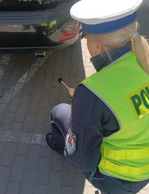 policjantka przy kontrolowanym aucie z sonometrem
