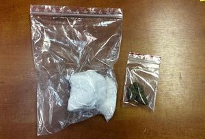 zatrzymany prowadzony przez policjantów i zabezpieczone narkotyki