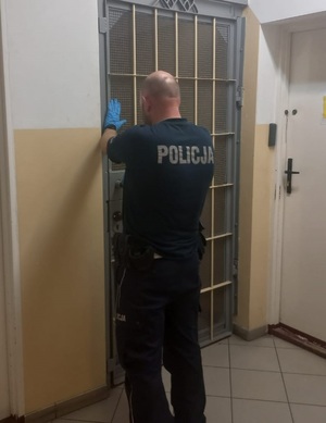 policjant przy celi zatrzymanego