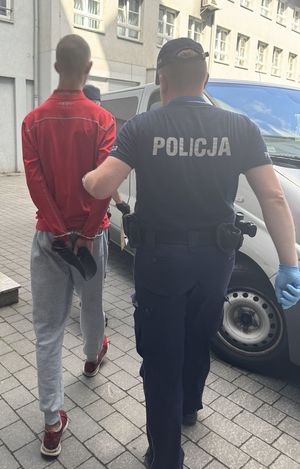 policjanci prowadzą do radiowozu poszukiwanych