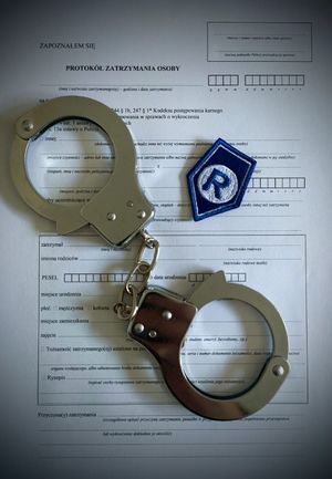 zdjęcie poglądowe do nietrzeźwego  kierującego, akta i położone na nich kajdanki