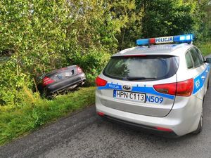 policyjny radiowóz i pojazd którym nietrzeźwy wjechał do rowu
