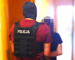 policjant prowadzi zatrzymanego