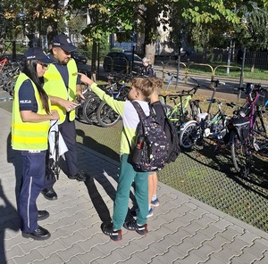 Policjanci promują bezpieczną jazdę na rowerach i hulajnogach elektrycznych.