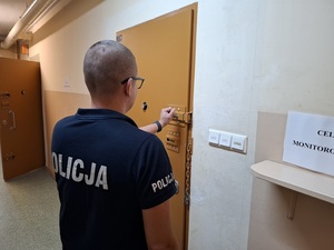 policjant zamyka drzwi pdoz