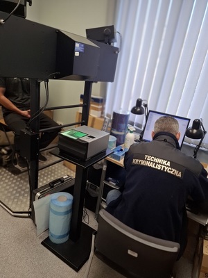 policjant z zatrzymanym i technik podczas dokumentacji