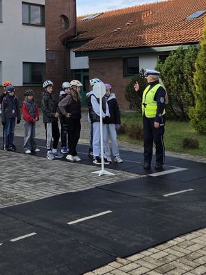 Egzamin na kartę rowerową pod nadzorem policjantki z ruchu drogowego.