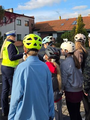Egzamin na kartę rowerową pod nadzorem policjantki z ruchu drogowego.