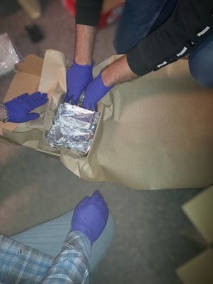 policjanci z zabezpieczonymi narkotykami i z zatrzymanym