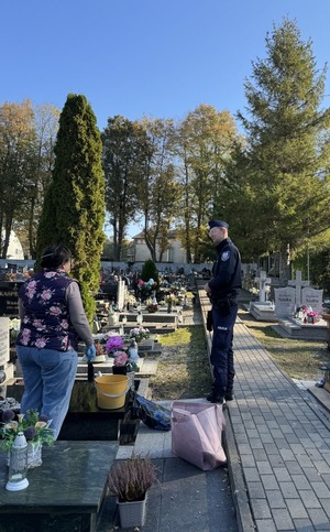 Policjanci z powiatu puckiego rozmawiają o zasadach bezpieczeństwie z odwiedzającymi groby przed Dniem Wszystkich Świętych.