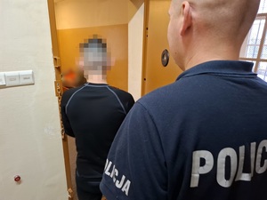 policjant z zatrzymanym i zniszczona wiata