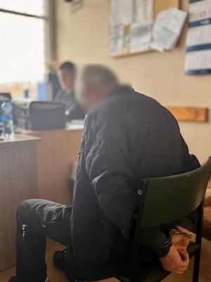 policjant podczas wypełniania dokumentacji z zatrzymanym