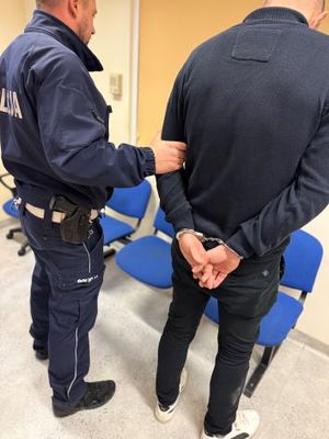 zatrzymany prowadzony przez policjanta