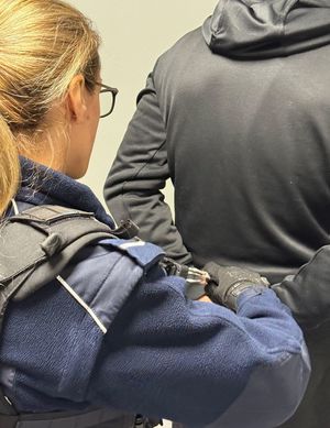 policjantka z zatrzymanym podejrzanym o zniszczenie mienia