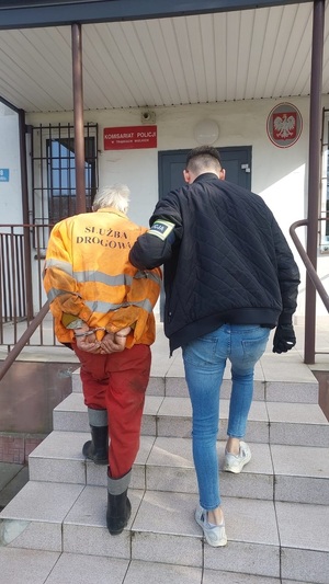 Zdjęcie przedstawia policjanta z zatrzymanym