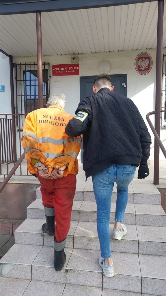 Zdjęcie przedstawia policjanta z zatrzymanym