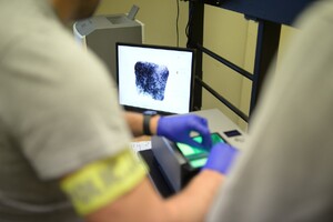 Zdjęcie przedstawia zatrzymanego w towarzystwie policjanta.