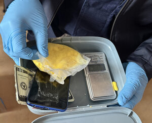 policjant z zatrzymanym i zabezpieczone narkotyki