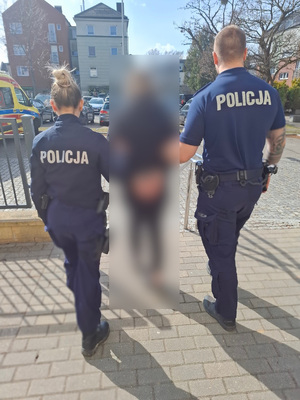 Policjanci wyprowadzają zatrzymanego.