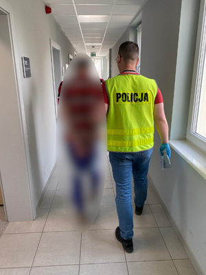 Zdjęcie przedstawia policjanta z zatrzymanym