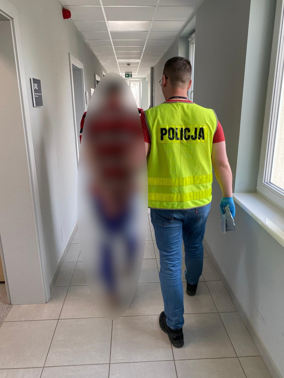 Zdjęcie przedstawia policjanta z zatrzymanym