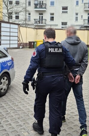 Zdjęcie przedstawia policjanta z zatrzymanym.
