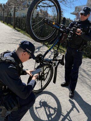 Zdjęcie przedstawia policjanta oraz rowerzystę z jednośladem