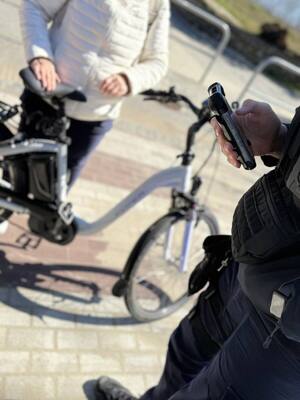 Zdjęcie przedstawia policjanta oraz rowerzystę z jednośladem